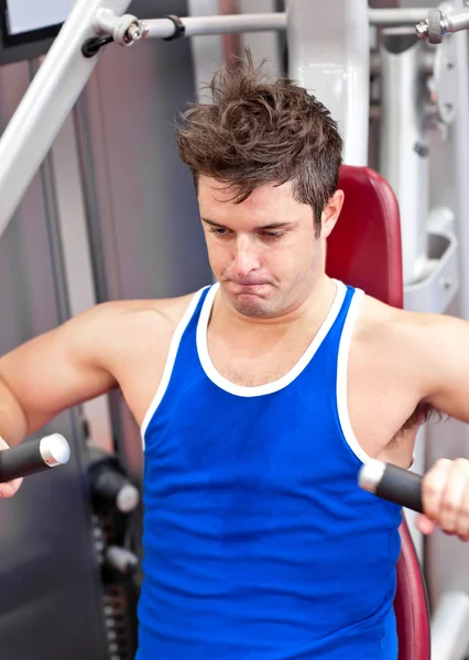 Prachtige man hard gewerkt aan een bench press in een fitnesscentrum — Stockfoto
