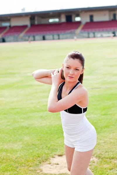 Atraktivní sportovní žena během výcviku vrh koulí v stadiu — Stock fotografie