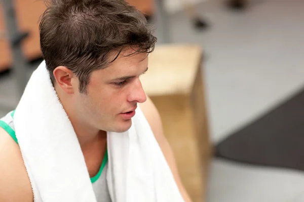 Hombre agotado con toalla alrededor del cuello después de ejercicios en una fi —  Fotos de Stock