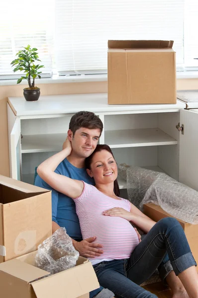Adorable pareja sentada en el suelo en su nueva casa durante r —  Fotos de Stock
