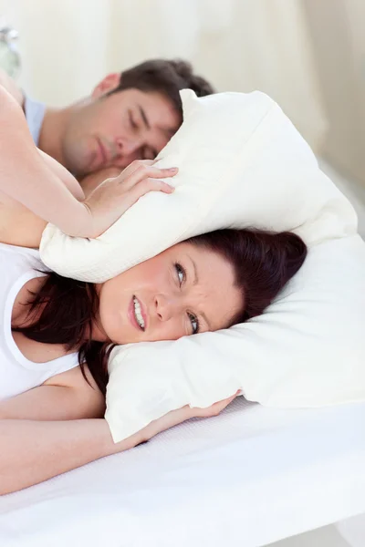 Gestresste zukünftige Mutter mit Kopf unter dem Kopfkissen im Bett mit ihrem Mann — Stockfoto