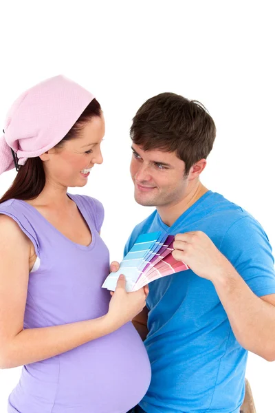 Happy couple choosing colors for the room of their future baby — Stock Photo, Image