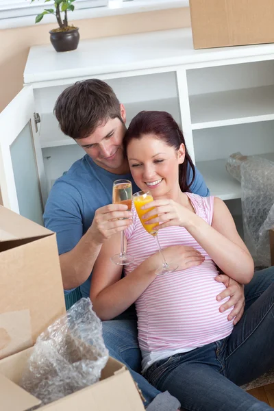 Cheerful couple celebrating pregnancy and removal with champagne — Stock Photo, Image