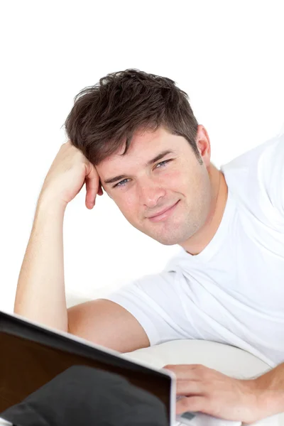 Parlak adamı yerde yatarken onun bilgisayar üzerinde çalışan — Stok fotoğraf