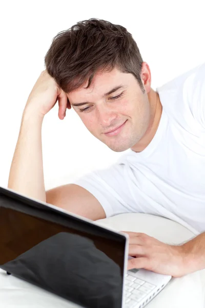 Homem pensativo usando seu laptop deitado no chão — Fotografia de Stock