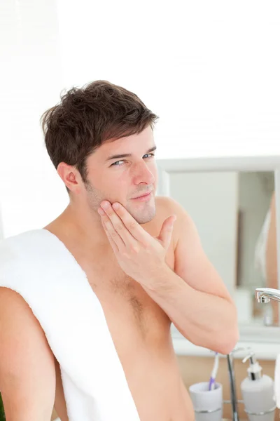 Young man putting aftershave in the bathroom — Stock Photo, Image