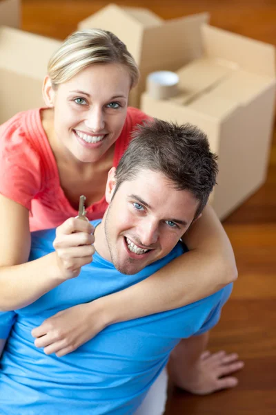 Retrato de um casal alegre em sua nova casa com mulher showin — Fotografia de Stock