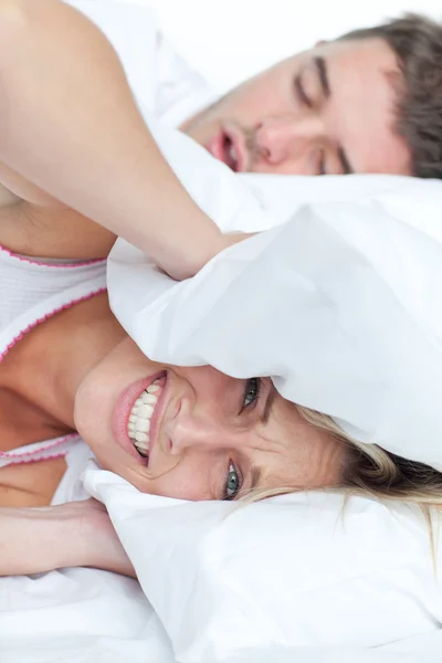 Stressed woman lying on the bed with her boyfriend snoring — Stock Photo, Image