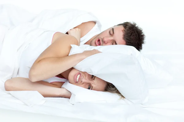 Naštvaná žena v posteli s přítelem chrápání — Stock fotografie