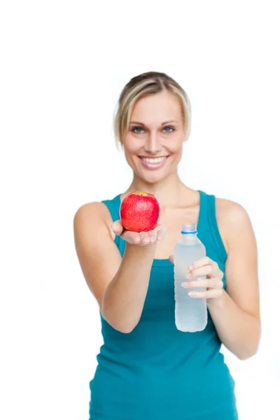 Mladá usměvavá žena drží láhev vody a jablko — Stock fotografie