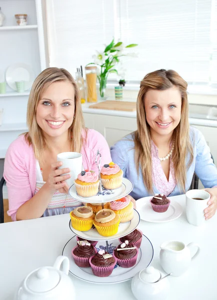 Retrato de dos amigas comiendo pasteles y bebiendo coff —  Fotos de Stock