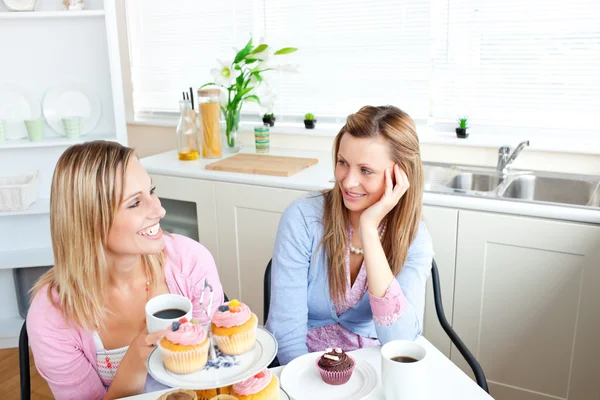 Two delighted female friends eating pastries and drinking coffee — Stock Photo, Image