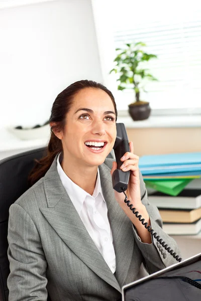 Веселая латиноамериканка-бизнесмен разговаривает по телефону перед ней — стоковое фото