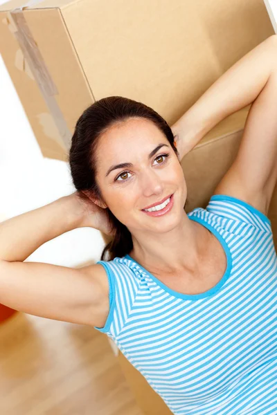 Mulher hispânica brilhante relaxando no meio de caixas no flo — Fotografia de Stock
