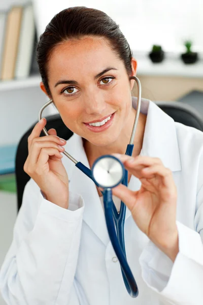 Assertive hispanic doctor holding a stethoscope at the camera — Stock Photo, Image