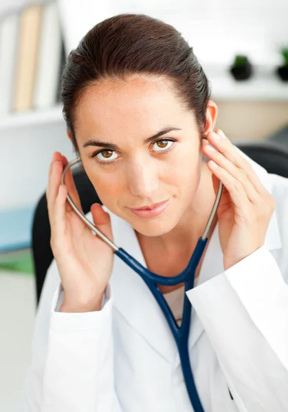 Pewnie kobieta lekarz za pomocą stetoskopu w jej biurze — Zdjęcie stockowe