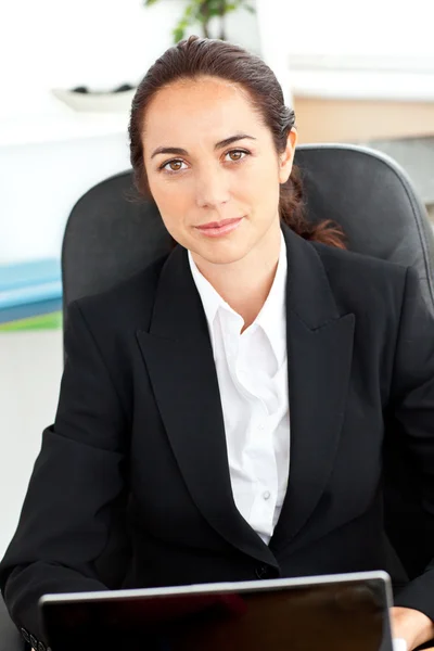 Mulher de negócios hispânica auto-confiante sentada em sua mesa na frente — Fotografia de Stock