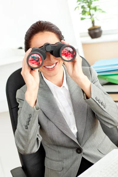 Mujer de negocios hispana brillante mirando a través de prismáticos sentados —  Fotos de Stock