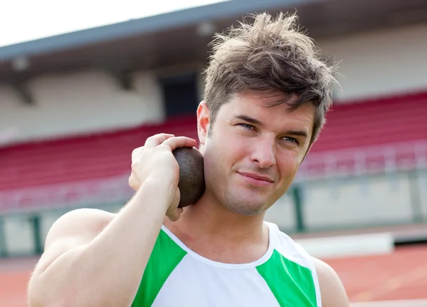 Concentrated male athlete preparing to throw weight — Stock Photo, Image