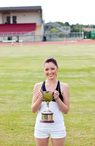 Gelukkig vrouwelijke atleet houdt een trofee — Stockfoto