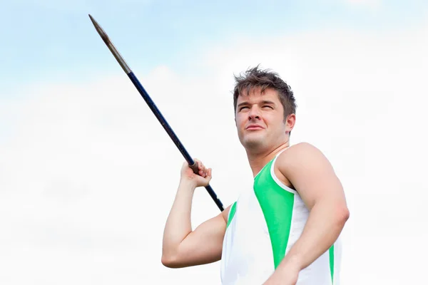 Handsome male throwing a javelin outdoors — Stock Photo, Image
