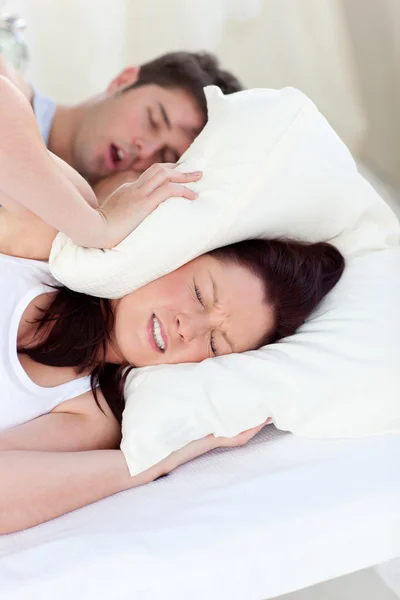 Jovem perturbada pelos roncos de seu namorado na cama — Fotografia de Stock