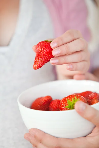 Close-up of a pregnant woman eating a bowl of strawberries — Stock Photo, Image