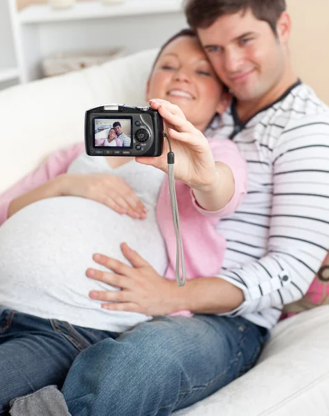 Крупный план радостной беременной женщины и ее мужа, делающего пикту — стоковое фото