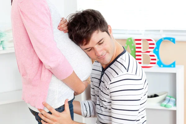 Primo piano di un uomo adorabile con la testa sulla pancia della sua donna incinta — Foto Stock