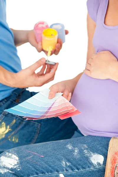 Close-up van een zwangere vrouw en haar echtgenoot kiezen van kleuren — Stockfoto