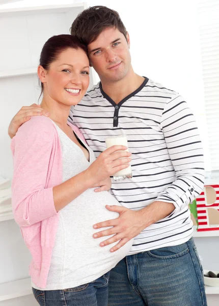 Retrato de una feliz mujer embarazada sosteniendo un vaso de leche y — Foto de Stock