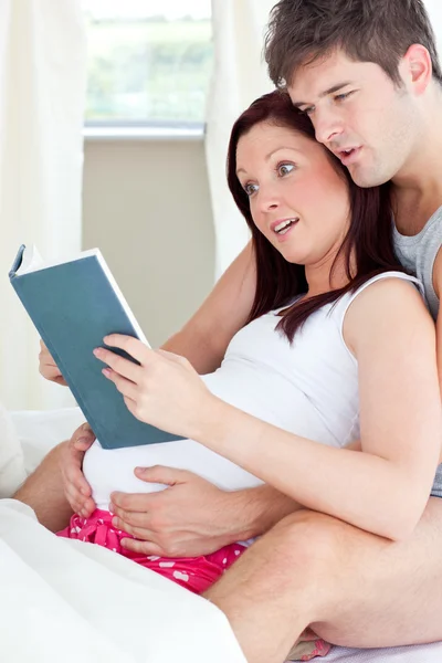 Close-up de uma mulher grávida chocada e seu marido lendo — Fotografia de Stock