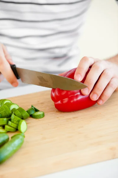 Close-up de um homem caucasiano cortando legumes na cozinha — Fotografia de Stock