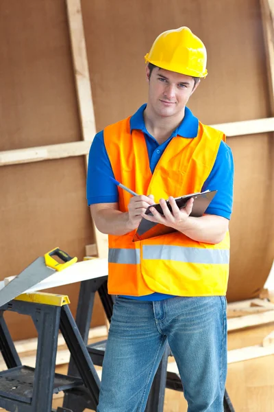Säker manlig arbetstagare som innehar ett urklipp — Stockfoto