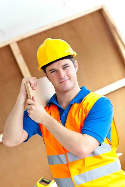 Magabiztos fiatal férfi dolgozó egy sárga sisak, kezében egy w — Stock Fotó