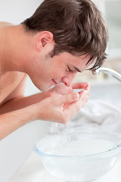 Θετική καυκάσιος άνθρωπος με ψεκασμό με νερό στο πρόσωπό του μετά το ξύρισμα — Φωτογραφία Αρχείου