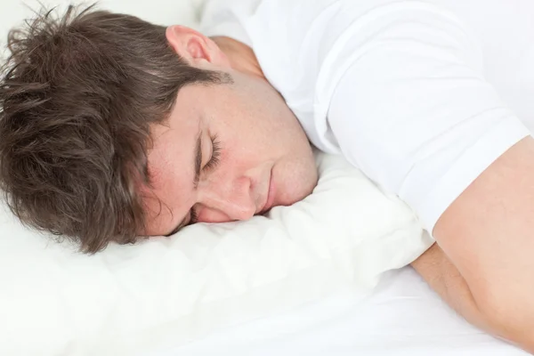 Junger kaukasischer Mann schläft in seinem Bett — Stockfoto
