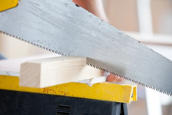 Close-up of a worker sawing a board — Stock Photo, Image