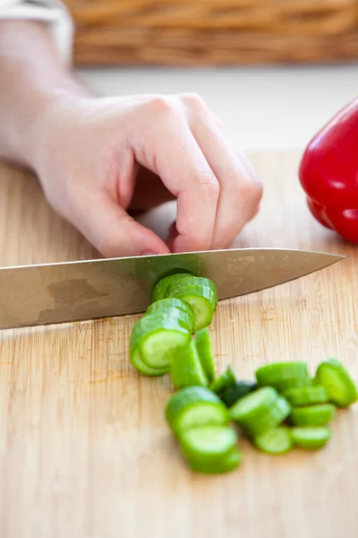 Крупним планом кавказький чоловік, що ріже огірок на кухні — стокове фото