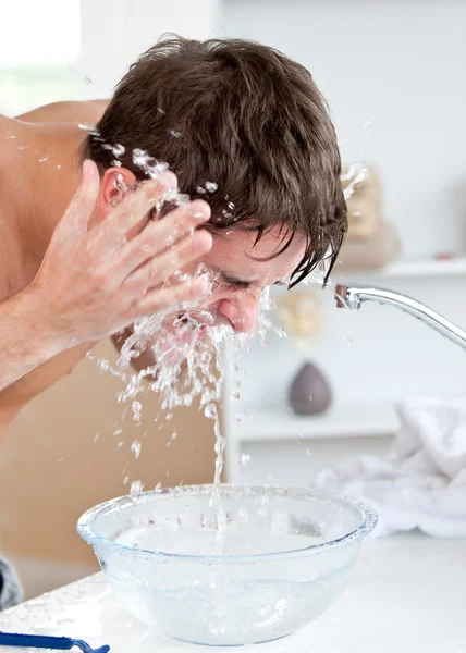 Ελκυστική καυκάσιος άνθρωπος με ψεκασμό με νερό στο πρόσωπό του μετά από shavin — Φωτογραφία Αρχείου