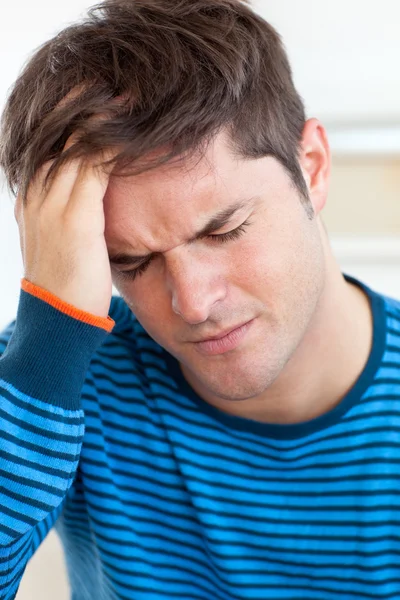 Schattig man met een hoofdpijn in de woonkamer — Stockfoto