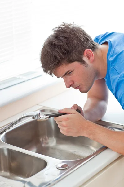 Manual man repairing his sink in the kitchen — Stock Photo, Image