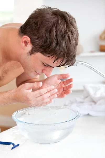 Bright caucasian man spraying water on his face after shaving in — Stock Photo, Image