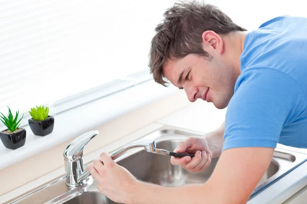 Zelfbewuste mens herstellen zijn wastafel in de keuken — Stockfoto