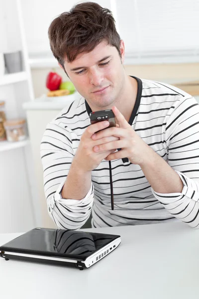 Homem caucasiano enviando uma mensagem de texto com seu celular na frente — Fotografia de Stock