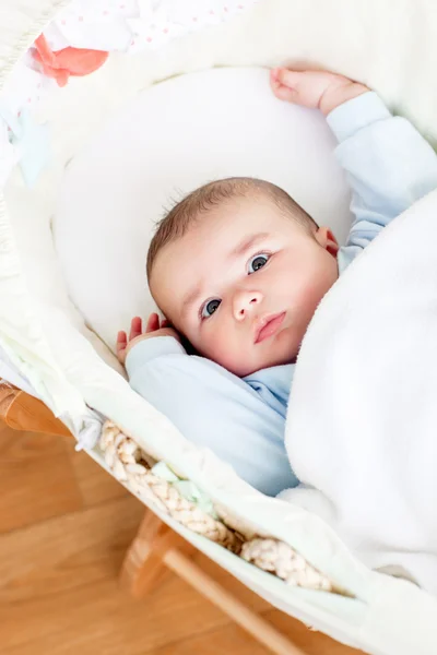 Portrait of a bright baby lying in his cradle — Stock Photo, Image