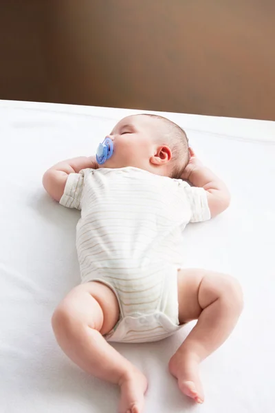 Portrait of a sweet baby with a pacifier sleeping on the sofa in — Stock Photo, Image