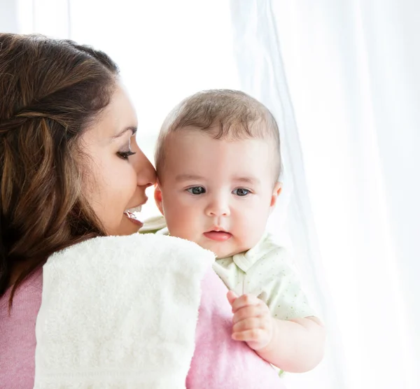Cheerful young mother taking care of her adorable baby — Stock Photo, Image