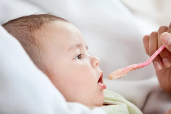 Yakın çekim yiyecek şirin bebeği veren bir anne — Stok fotoğraf