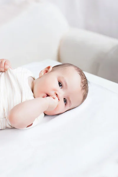 Portrait of a cute baby lying on table in the living-room — Stock Photo, Image